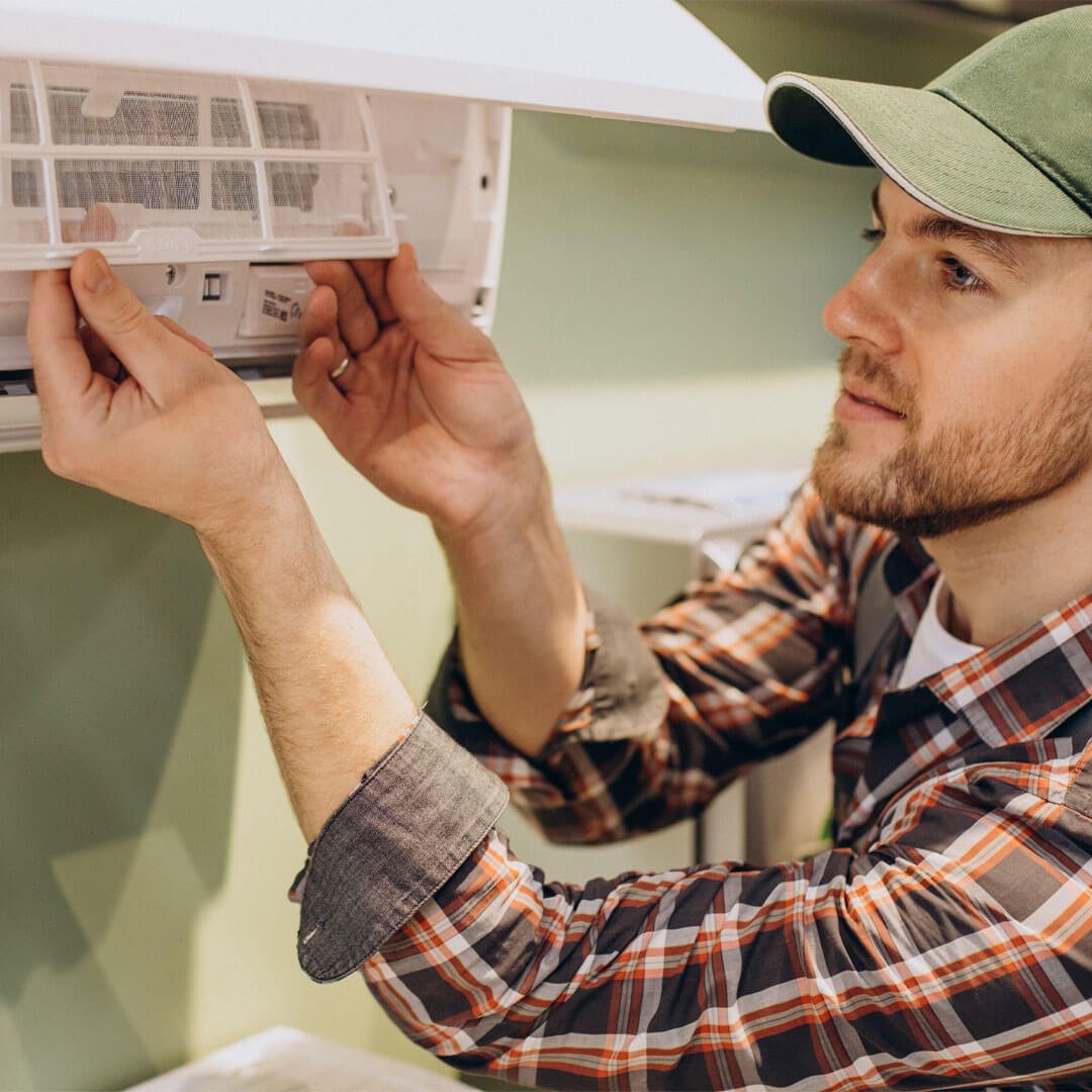 RAD employee performing maintenance on a split system